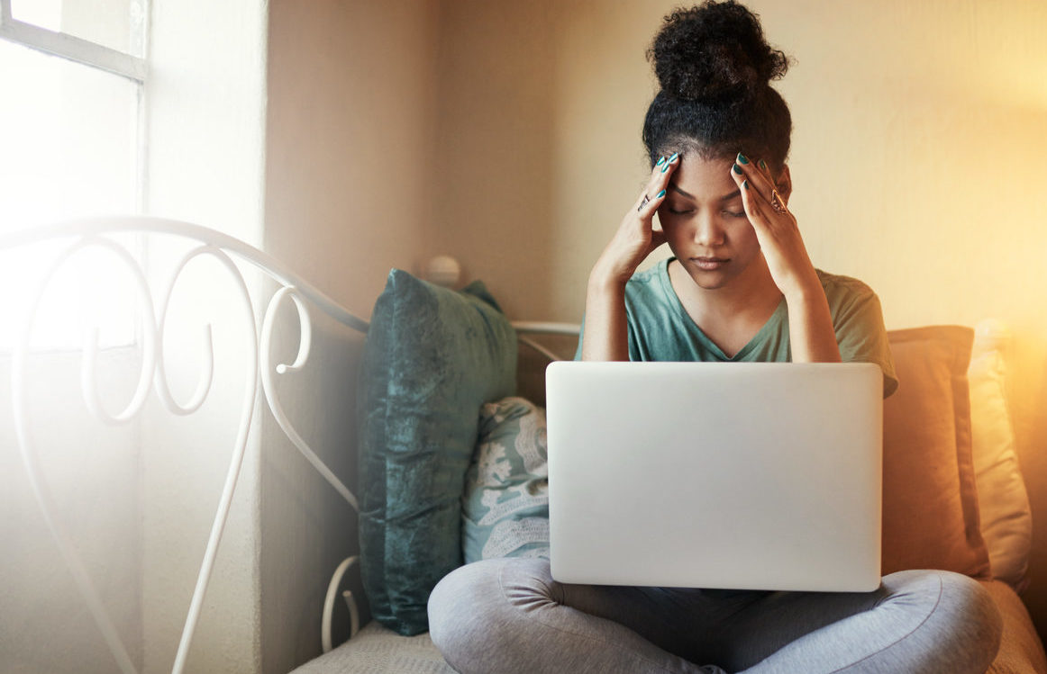 Woman looking at her laptop in despair