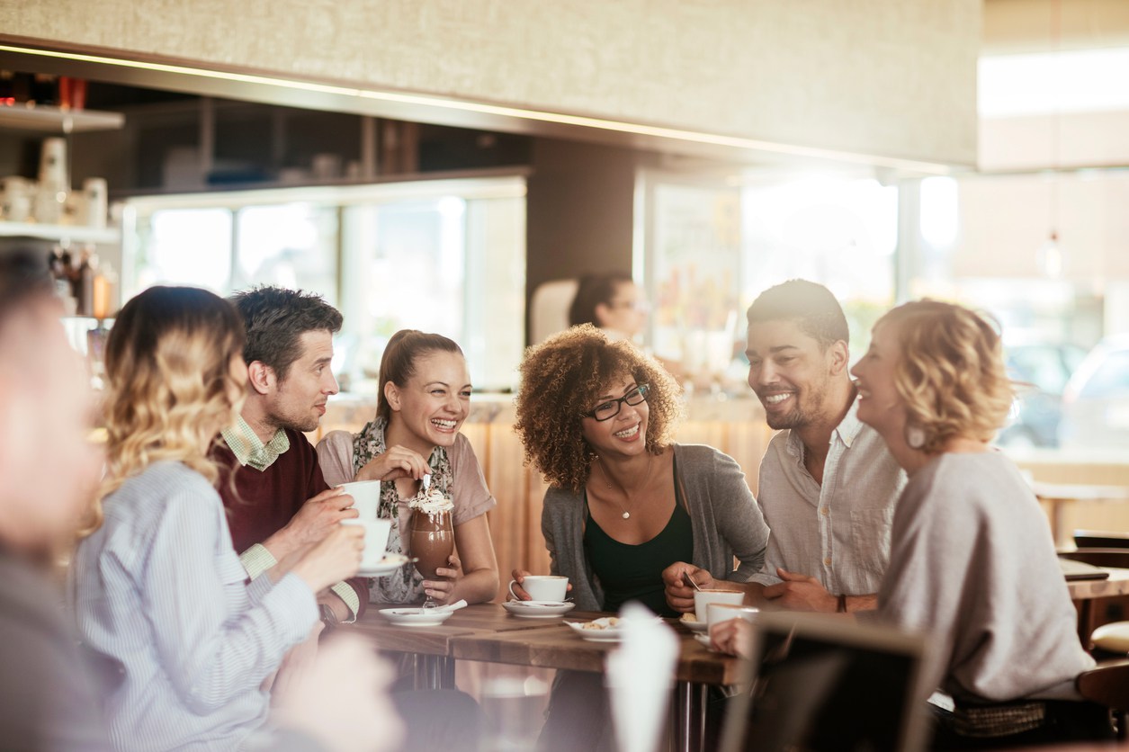 Happy group of Christian singles getting to know each other at an event in a coffee shop