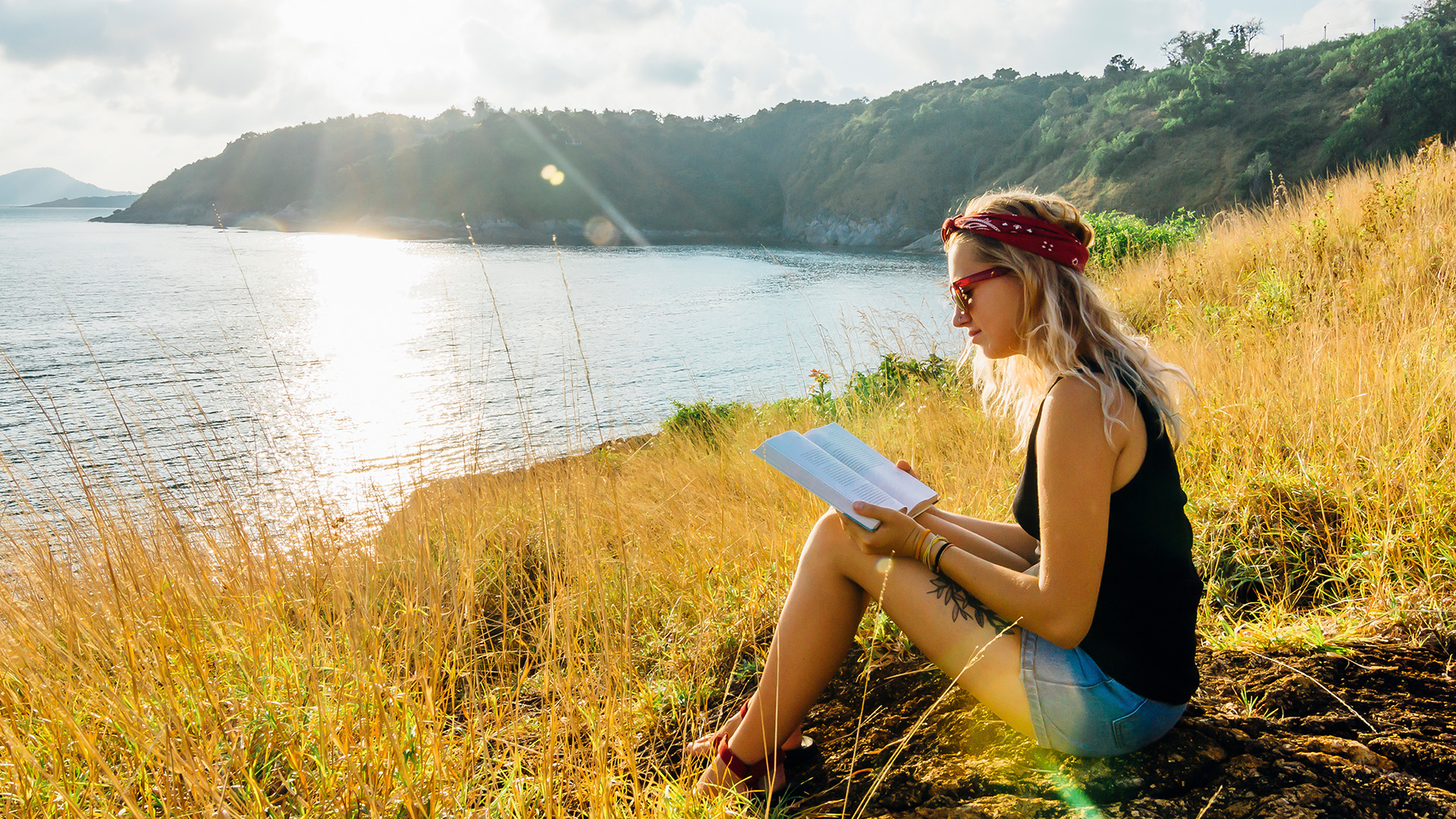 woman reading inspirational bible verses on a sunny cliff top